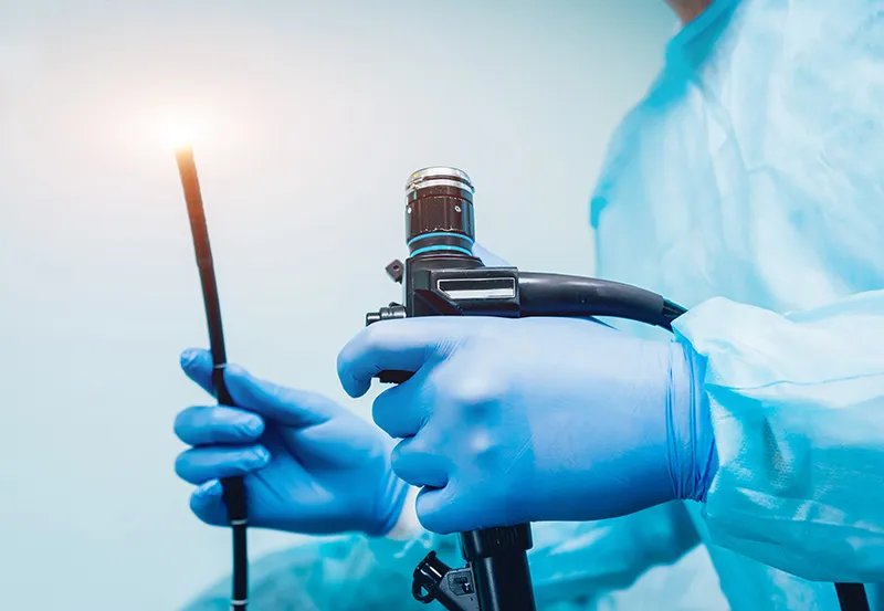 Surgeon preparing for an endoscopy test in a clinical setting.